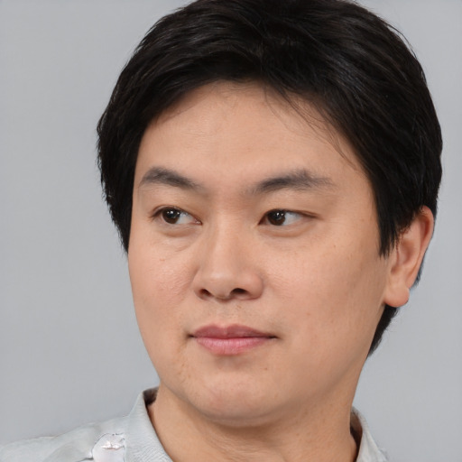 Joyful asian young-adult male with short  black hair and brown eyes