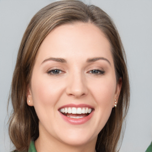 Joyful white young-adult female with medium  brown hair and green eyes