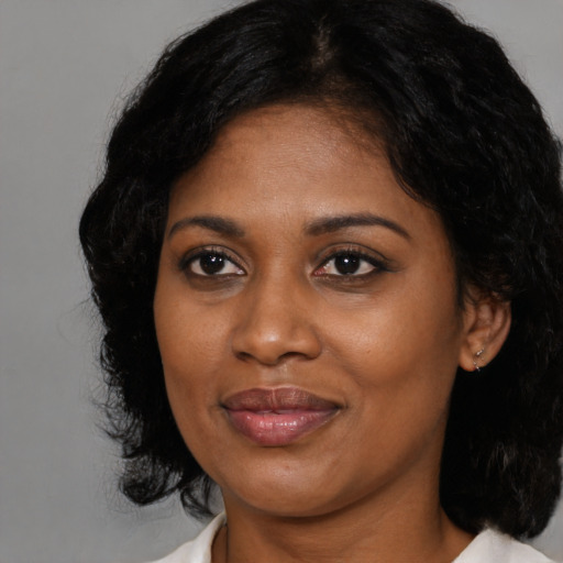 Joyful black young-adult female with medium  black hair and brown eyes