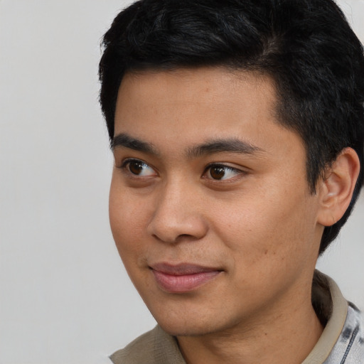 Joyful asian young-adult male with short  black hair and brown eyes