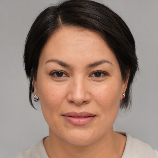 Joyful asian adult female with medium  brown hair and brown eyes
