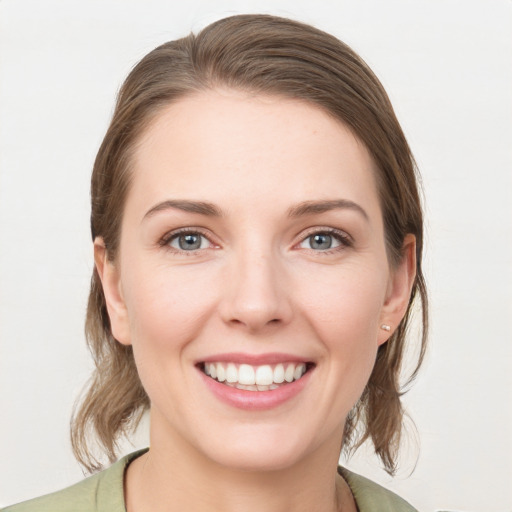 Joyful white young-adult female with medium  brown hair and grey eyes