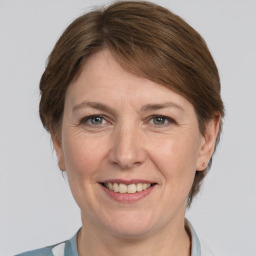 Joyful white adult female with medium  brown hair and grey eyes