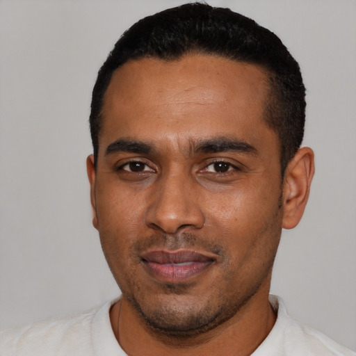Joyful black young-adult male with short  black hair and brown eyes