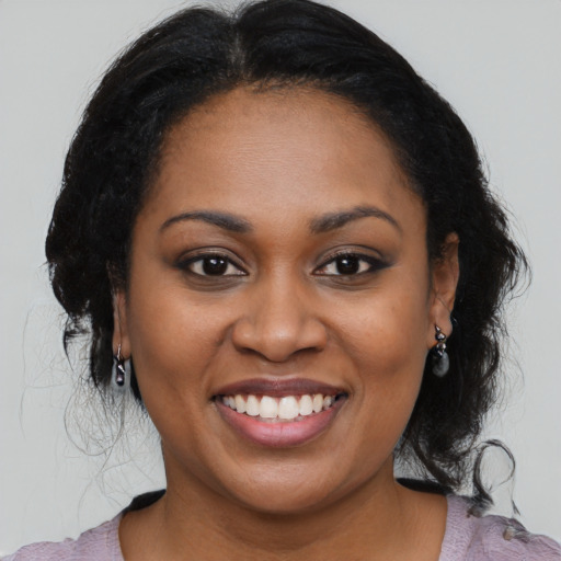 Joyful black young-adult female with medium  black hair and brown eyes