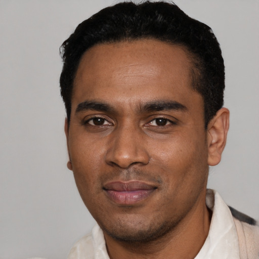 Joyful black young-adult male with short  black hair and brown eyes