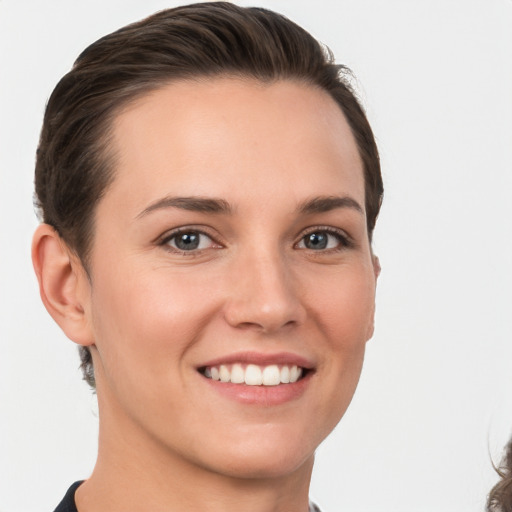 Joyful white young-adult female with short  brown hair and grey eyes