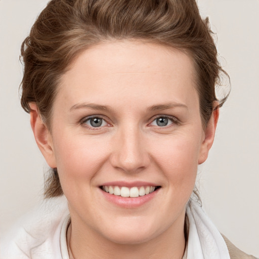 Joyful white young-adult female with short  brown hair and blue eyes