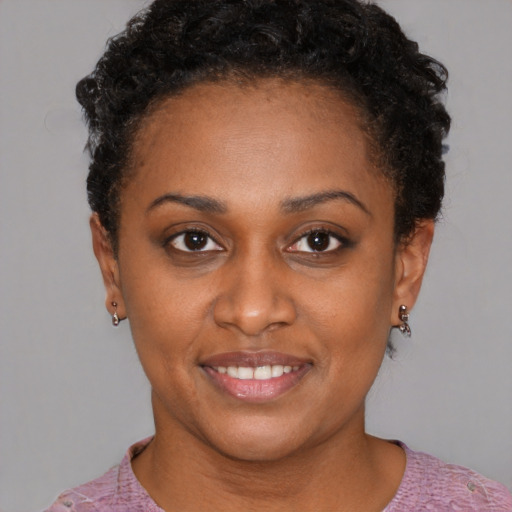 Joyful black young-adult female with short  brown hair and brown eyes