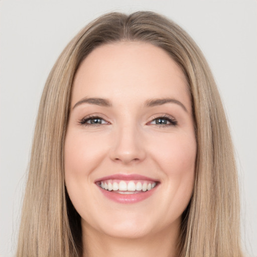 Joyful white young-adult female with long  brown hair and brown eyes