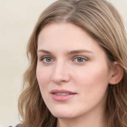 Joyful white young-adult female with long  brown hair and blue eyes