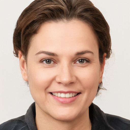 Joyful white young-adult female with medium  brown hair and grey eyes