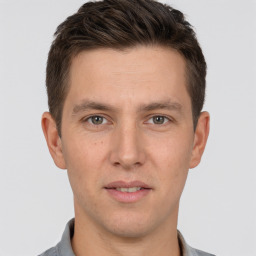 Joyful white young-adult male with short  brown hair and brown eyes