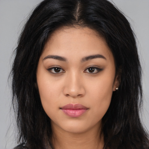 Joyful latino young-adult female with long  brown hair and brown eyes
