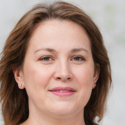 Joyful white adult female with medium  brown hair and grey eyes