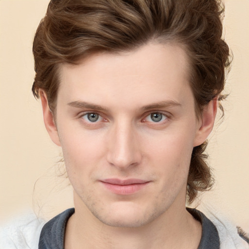 Joyful white young-adult male with medium  brown hair and grey eyes