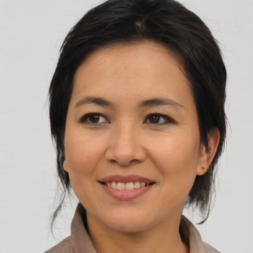 Joyful asian adult female with medium  brown hair and brown eyes