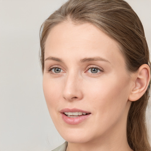 Joyful white young-adult female with long  brown hair and blue eyes