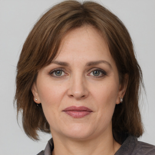 Joyful white adult female with medium  brown hair and grey eyes