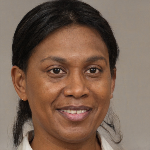 Joyful black adult female with medium  brown hair and brown eyes