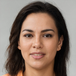 Joyful latino young-adult female with long  brown hair and brown eyes