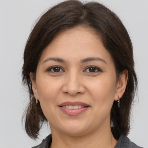 Joyful white adult female with medium  brown hair and brown eyes