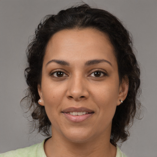 Joyful latino adult female with medium  brown hair and brown eyes