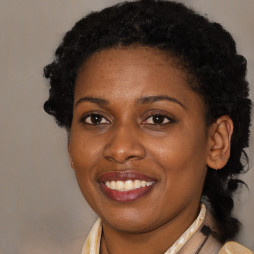 Joyful black young-adult female with medium  brown hair and brown eyes