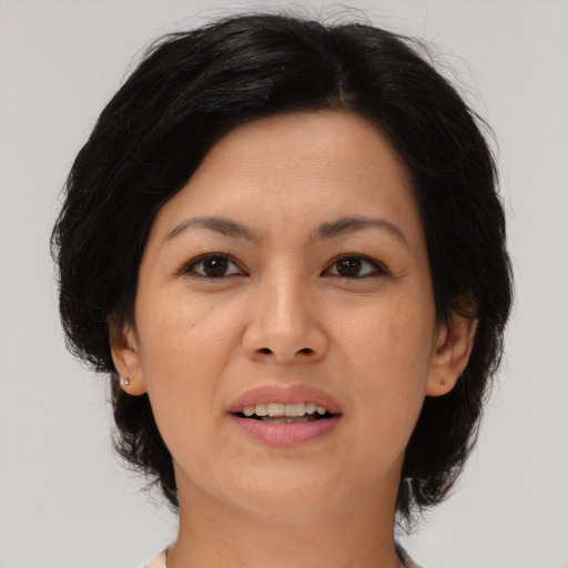 Joyful latino adult female with medium  brown hair and brown eyes