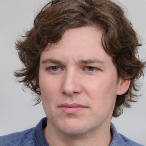 Joyful white young-adult male with medium  brown hair and blue eyes