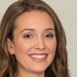 Joyful white young-adult female with long  brown hair and green eyes