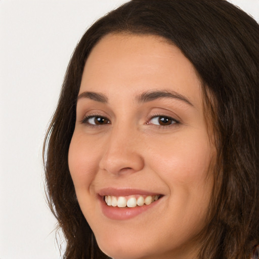 Joyful white young-adult female with long  brown hair and brown eyes