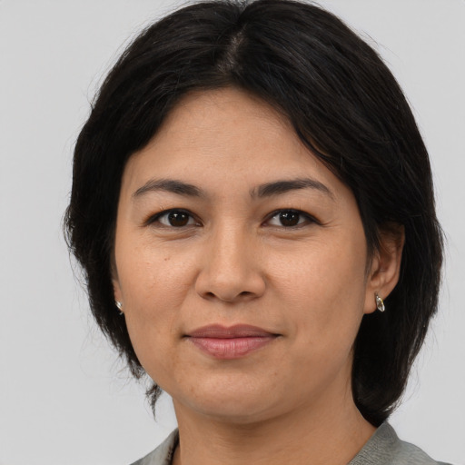 Joyful asian adult female with medium  brown hair and brown eyes
