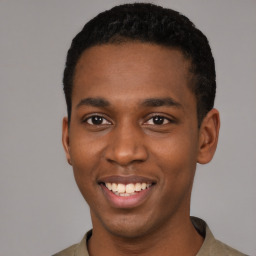 Joyful black young-adult male with short  black hair and brown eyes