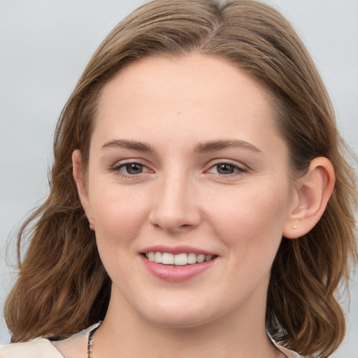 Joyful white young-adult female with long  brown hair and blue eyes