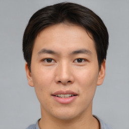 Joyful asian young-adult male with short  brown hair and brown eyes