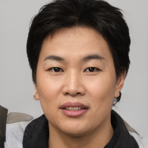 Joyful asian adult female with medium  brown hair and brown eyes