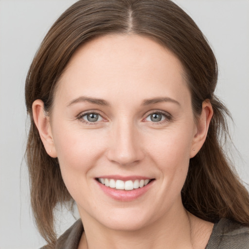 Joyful white young-adult female with medium  brown hair and grey eyes