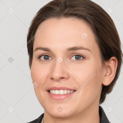 Joyful white young-adult female with medium  brown hair and grey eyes