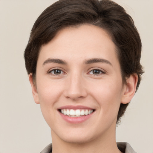 Joyful white young-adult female with short  brown hair and brown eyes