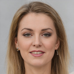 Joyful white young-adult female with long  brown hair and green eyes