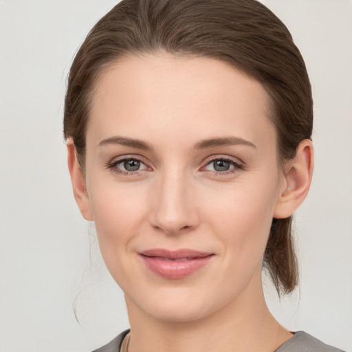 Joyful white young-adult female with medium  brown hair and grey eyes