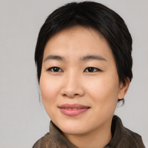Joyful asian young-adult female with medium  black hair and brown eyes
