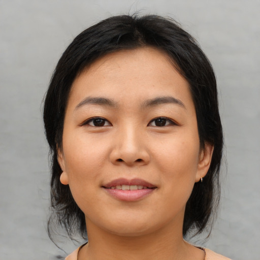 Joyful asian young-adult female with medium  brown hair and brown eyes