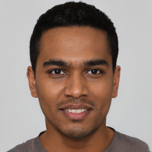 Joyful black young-adult male with short  black hair and brown eyes