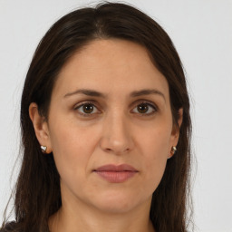 Joyful white adult female with long  brown hair and brown eyes