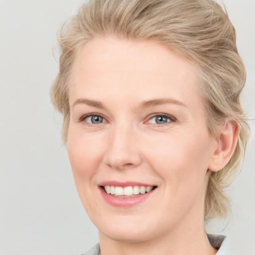 Joyful white young-adult female with medium  brown hair and blue eyes