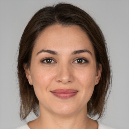 Joyful white young-adult female with medium  brown hair and brown eyes