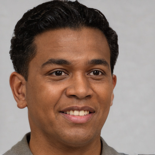 Joyful latino young-adult male with short  brown hair and brown eyes