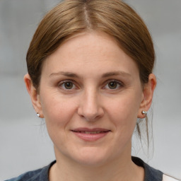 Joyful white adult female with medium  brown hair and grey eyes